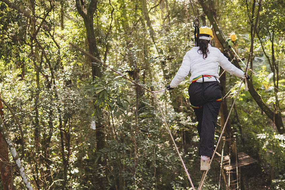 Turista participando de uma aventura sob as árvores em Brumadinho