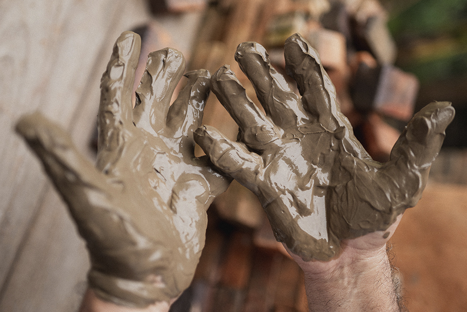Mão na massa - Mãos sujas de barro durante produção de peças de cerâmica artesanal em uma vivência turística em Brumadinho, Minas Gerais