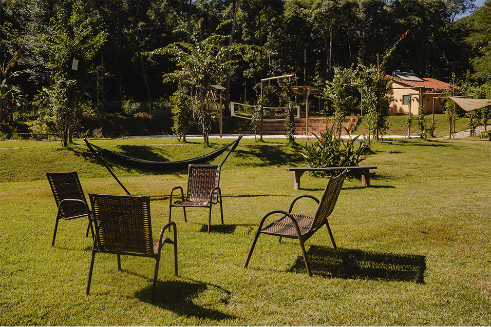 Cadeiras no quintal gramado com vista para a mata na Ecovila Coração da Mata em Brumadinho