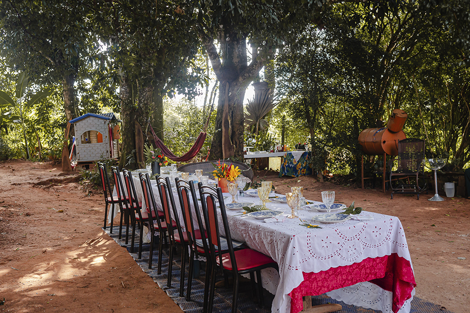 Mesa de almoço montada embaixo das árvores, para receber turistas em Aprendendo no Quintal em Brumadinho